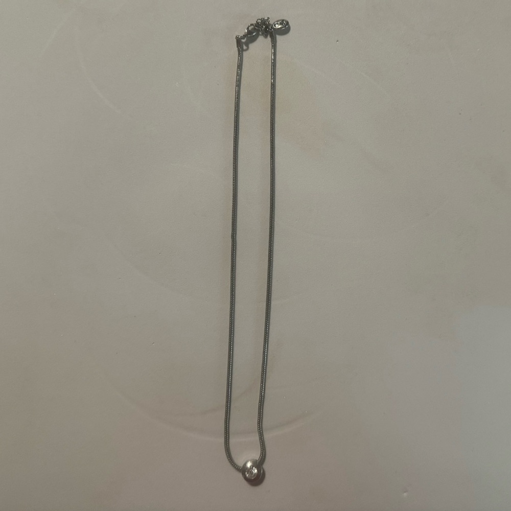 Silver necklace with rhinestone or cubic zirconia.